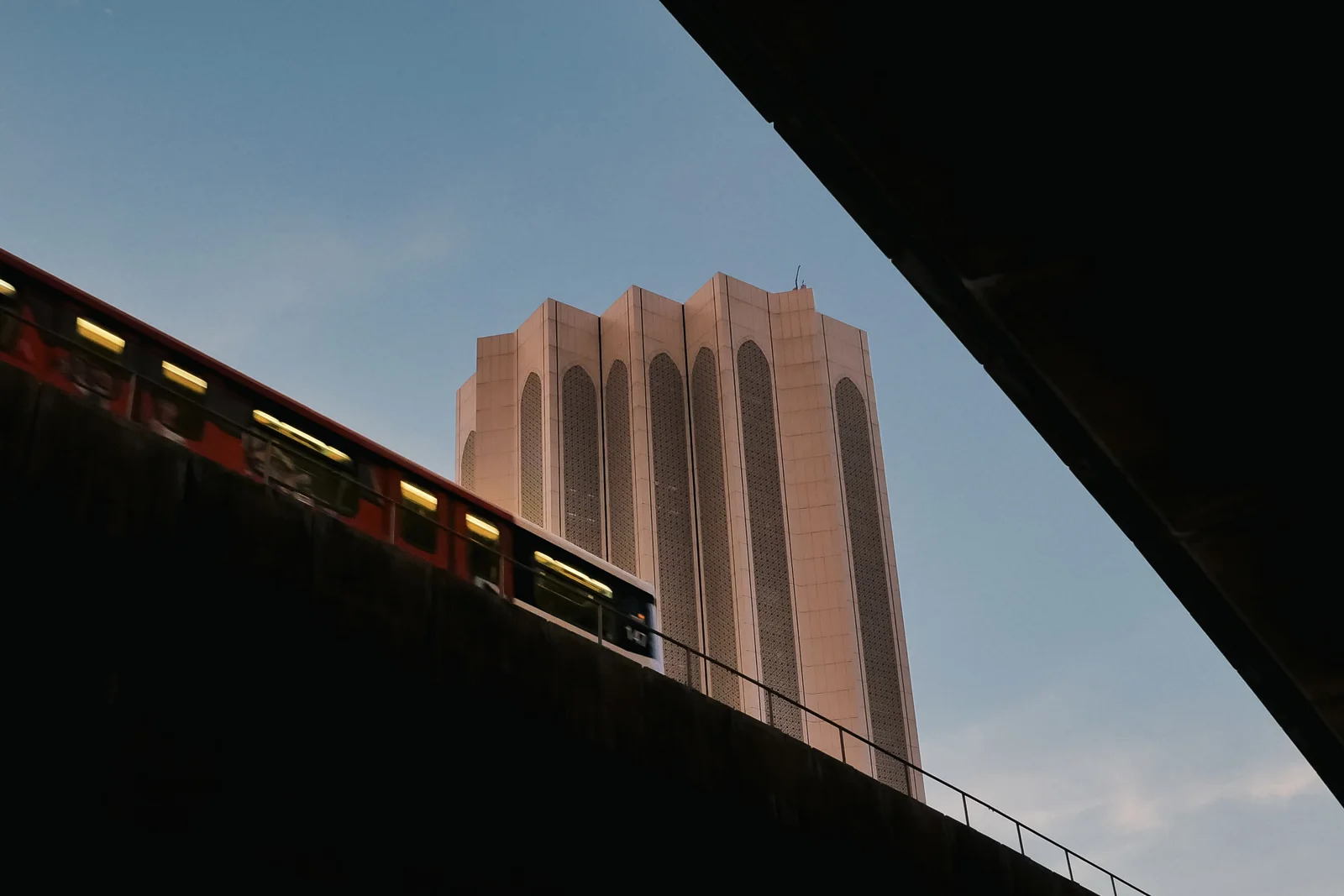 Monorail crossing above a city street at dusk