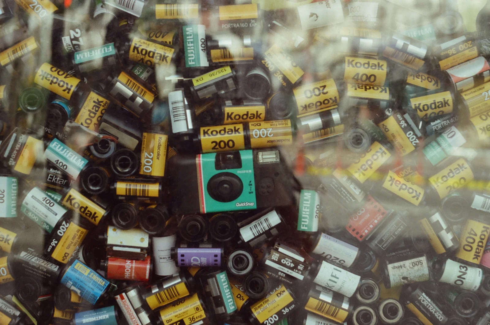 A pile of film canisters and trinkets, shot on film