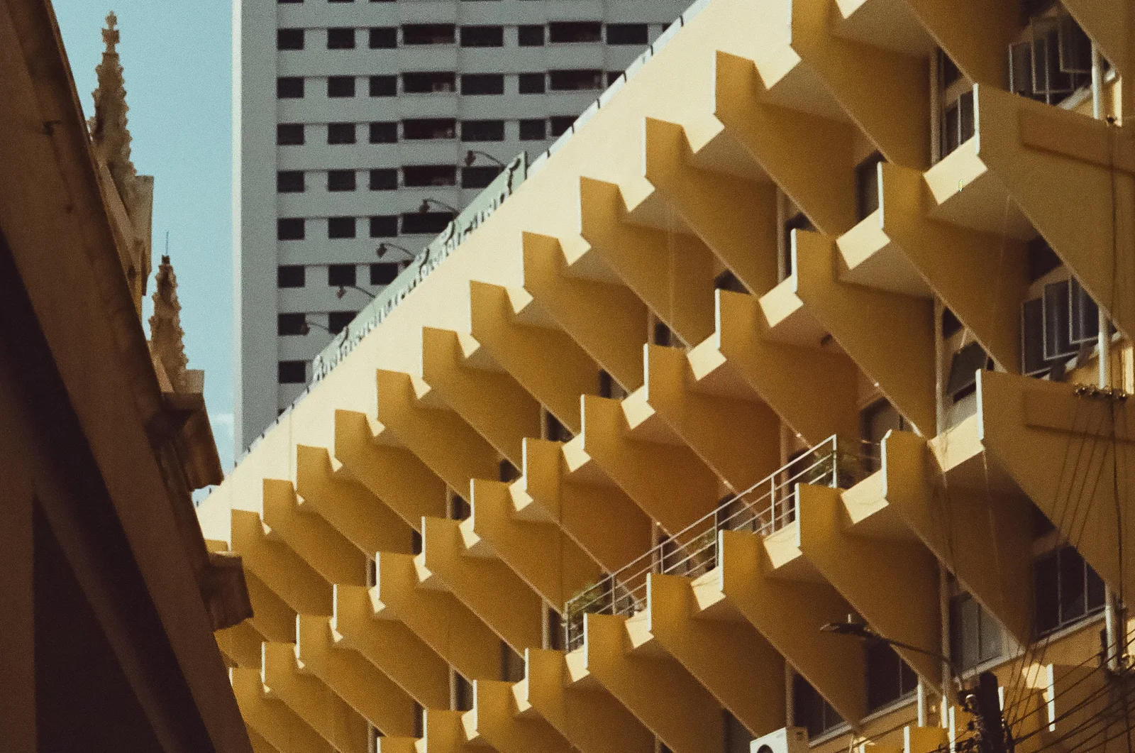A yellow balcony facade in afternoon light, shot on film