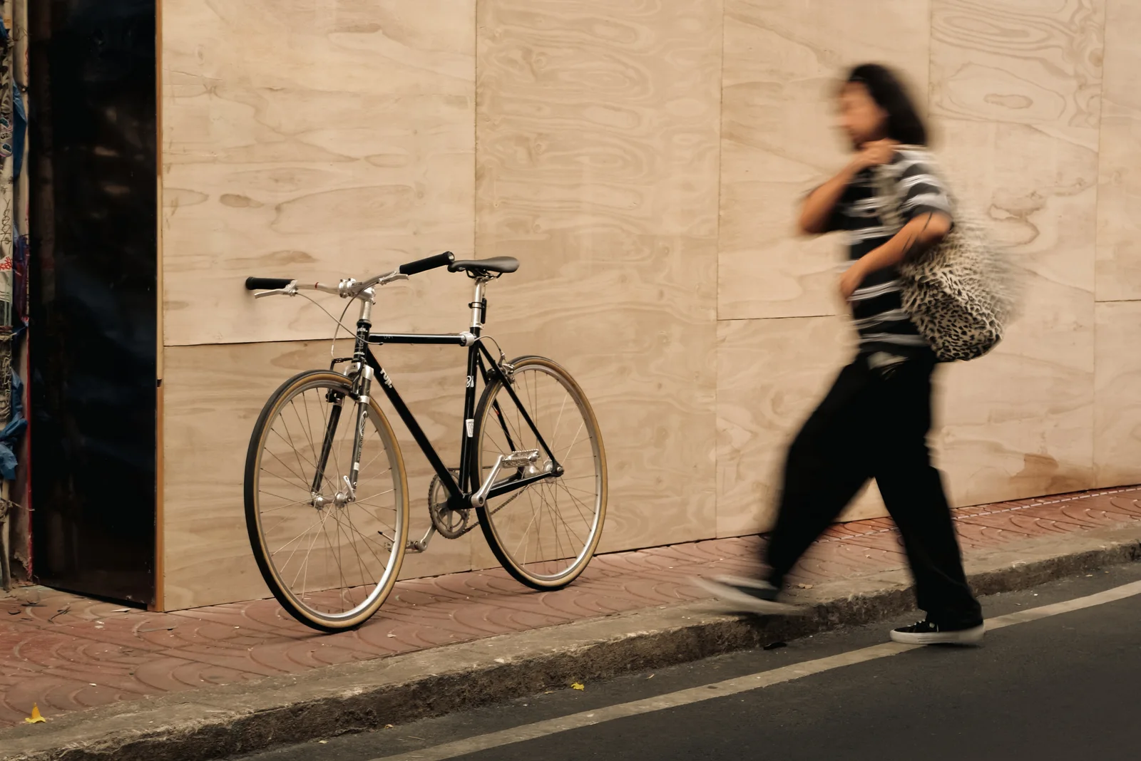 Someone walking a bike past a wall